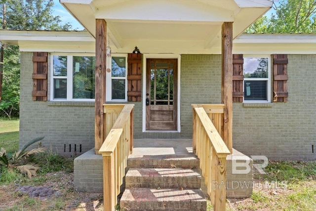 view of exterior entry featuring brick siding
