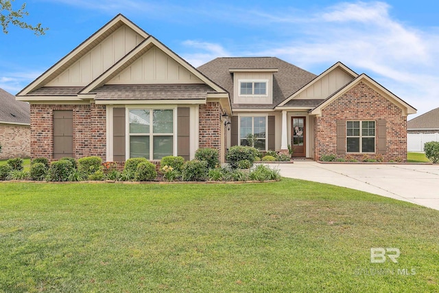craftsman-style house with a shingled roof, board and batten siding, a front yard, and brick siding