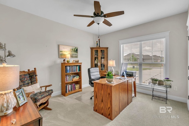 office area featuring baseboards, a ceiling fan, and light colored carpet