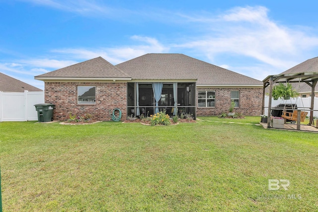 rear view of property featuring brick siding, fence, and a yard