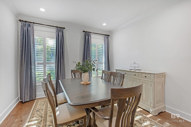 dining room featuring light hardwood / wood-style flooring and crown molding