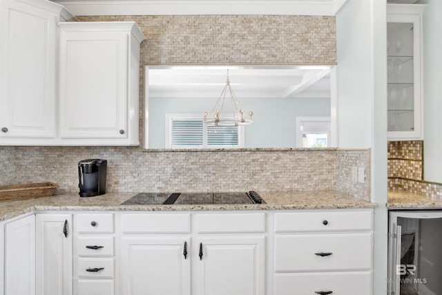1219 Parasol Pl, Perdido Key, FL 32507 - kitchen with beverage cooler, black electric stovetop, a chandelier, tasteful backsplash, and white cabinets