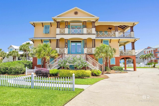 1219 Parasol Pl, Perdido Key, FL 32507 - coastal home with a balcony, stairs, a carport, and a porch