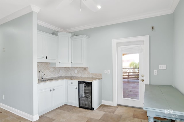 1219 Parasol Pl, Perdido Key, FL 32507 - kitchen featuring wine cooler, a sink, light countertops, backsplash, and white cabinets