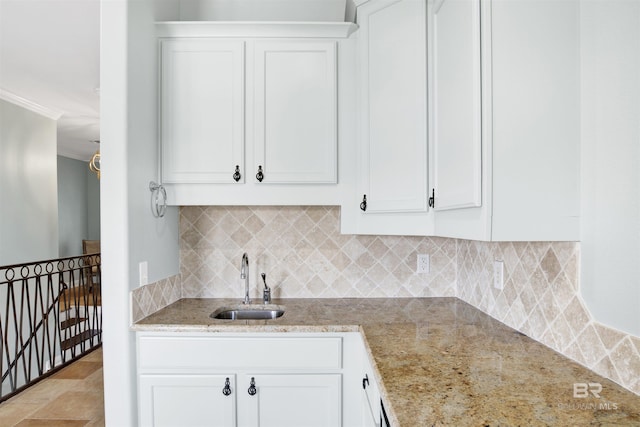 1219 Parasol Pl, Perdido Key, FL 32507 - kitchen with a sink, white cabinetry, ornamental molding, light stone countertops, and decorative backsplash