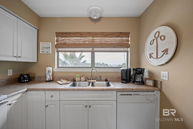 kitchen with dishwasher, sink, and white cabinets