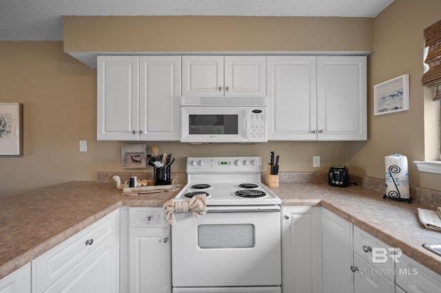 kitchen with white cabinetry and white appliances