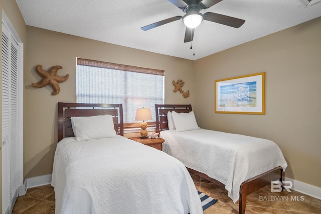 bedroom with a textured ceiling, ceiling fan, and a closet