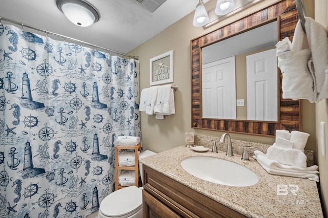 bathroom featuring vanity, curtained shower, and toilet