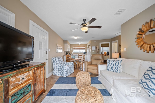 tiled living room with ceiling fan