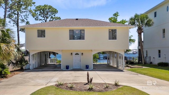 26750 Moses Rd, Orange Beach, AL 36561 - view of front of home with a carport, concrete driveway, stucco siding, and roof with shingles