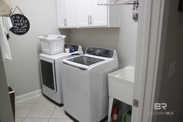 laundry room featuring cabinets, light tile patterned floors, independent washer and dryer, and sink