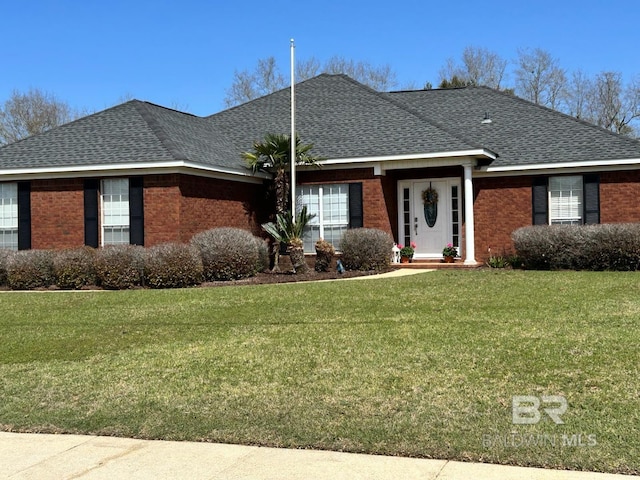 ranch-style house with brick siding, a front yard, and a shingled roof