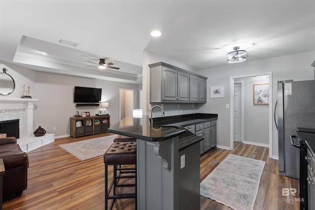 kitchen featuring a tray ceiling, open floor plan, freestanding refrigerator, and gray cabinetry