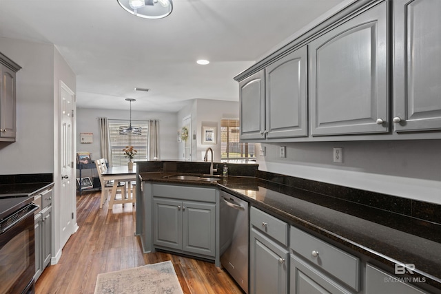 kitchen featuring gray cabinetry, dishwasher, wood finished floors, electric range, and a sink