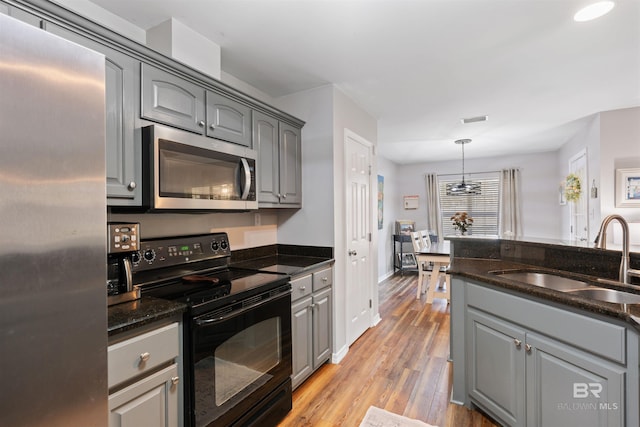 kitchen with gray cabinets, stainless steel appliances, and a sink