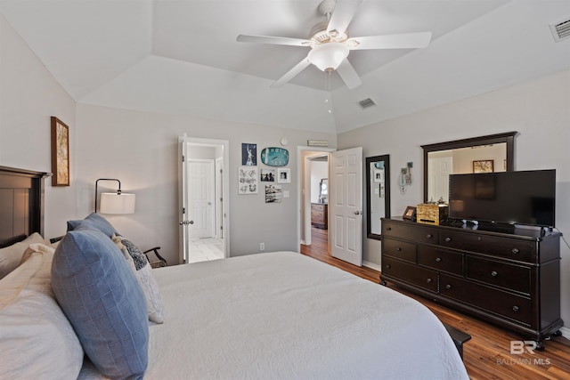 bedroom featuring visible vents, a raised ceiling, and wood finished floors