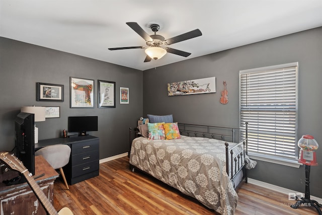 bedroom with ceiling fan, baseboards, and wood finished floors