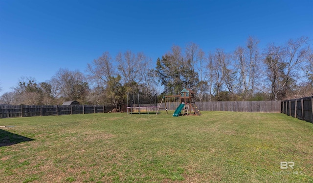 view of yard with a playground, a trampoline, and a fenced backyard