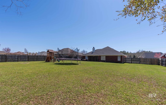 view of yard with a fenced backyard and a trampoline