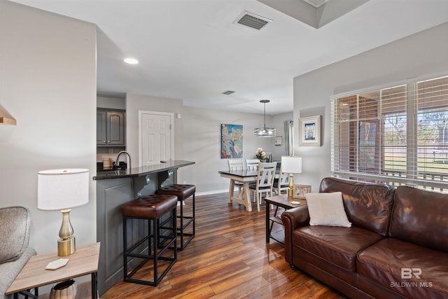 living room featuring recessed lighting, visible vents, baseboards, and dark wood-type flooring