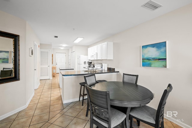 dining room featuring baseboards, visible vents, and light tile patterned flooring