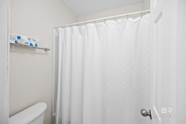 bathroom featuring a shower with curtain and toilet