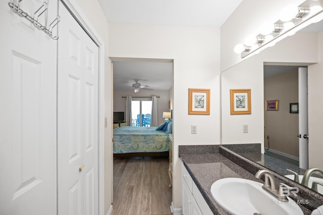 ensuite bathroom featuring ceiling fan, ensuite bathroom, wood finished floors, and vanity