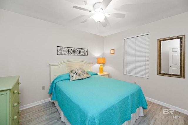 bedroom featuring ceiling fan, baseboards, and wood finished floors