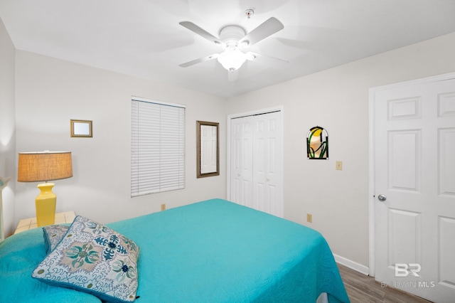 bedroom featuring ceiling fan, a closet, wood finished floors, and baseboards