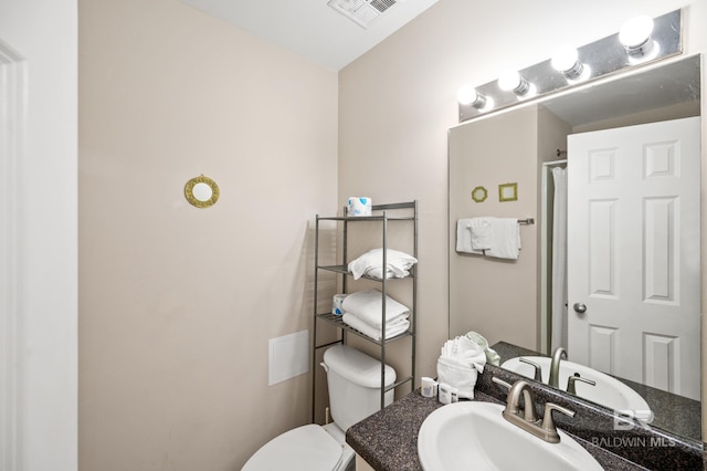 bathroom with toilet, visible vents, and vanity