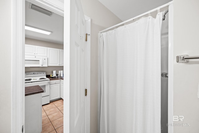 full bathroom with curtained shower, tile patterned flooring, and visible vents