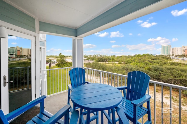 balcony with a view of city and outdoor dining space