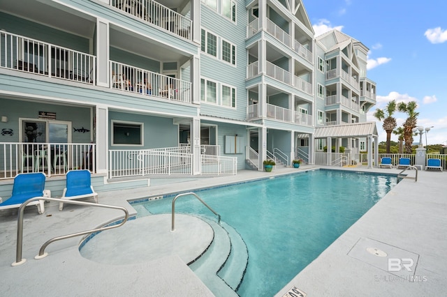 community pool with a patio area and fence