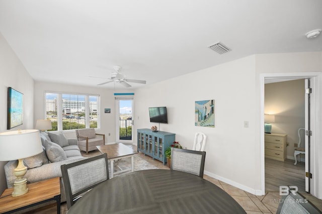 interior space featuring a ceiling fan, visible vents, baseboards, and light tile patterned floors