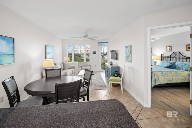 dining space featuring ceiling fan, baseboards, and light tile patterned floors