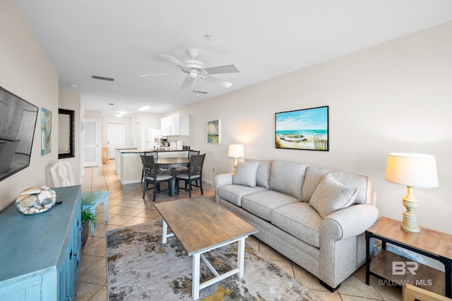 living area with light tile patterned floors, ceiling fan, and visible vents