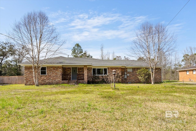 ranch-style home featuring brick siding, a front yard, and fence