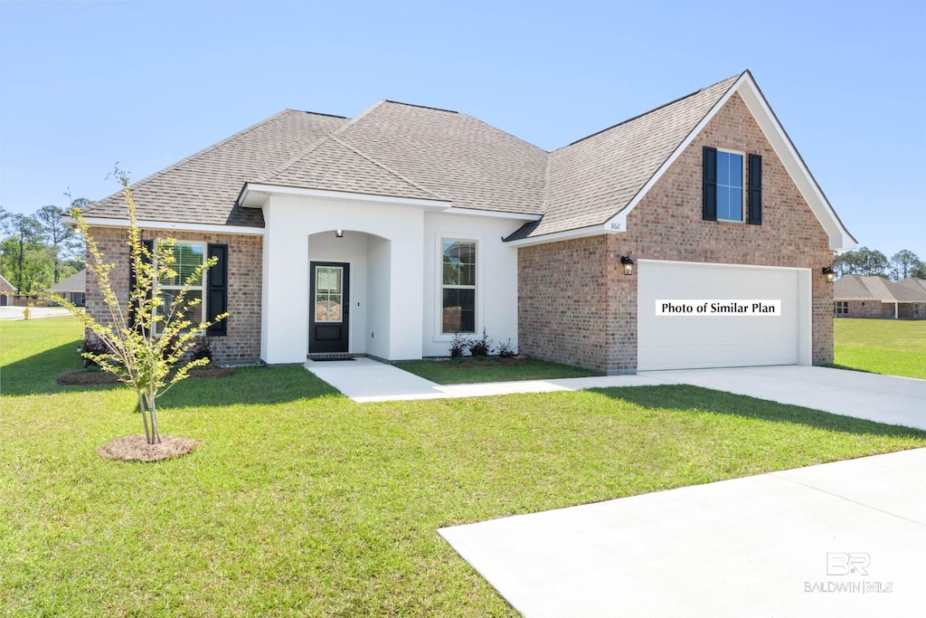 12647 Wagner Ave, Spanish Fort, AL 36527 - traditional home with brick siding, a shingled roof, a front lawn, and driveway