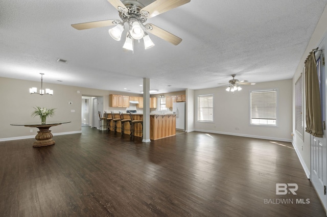 5584 Pensacola Ave, Orange Beach, AL 36561 - unfurnished living room featuring a textured ceiling, visible vents, ceiling fan with notable chandelier, and dark wood-type flooring