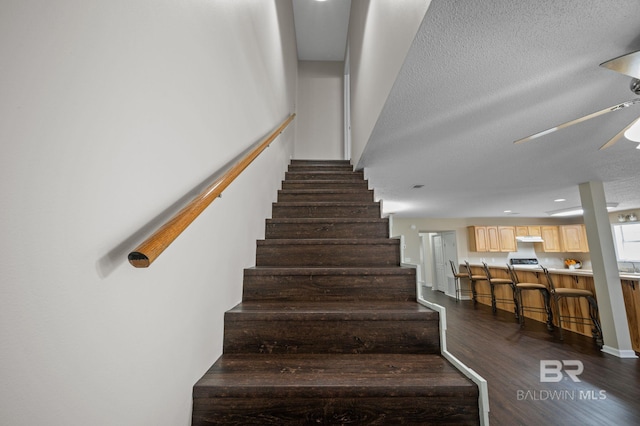 5584 Pensacola Ave, Orange Beach, AL 36561 - stairs with ceiling fan, bar area, and wood finished floors