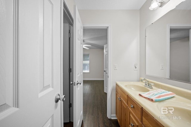 5584 Pensacola Ave, Orange Beach, AL 36561 - bathroom featuring baseboards, a textured ceiling, wood finished floors, and vanity