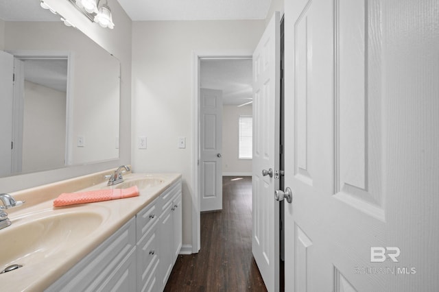 5584 Pensacola Ave, Orange Beach, AL 36561 - bathroom featuring double vanity, baseboards, a sink, and wood finished floors