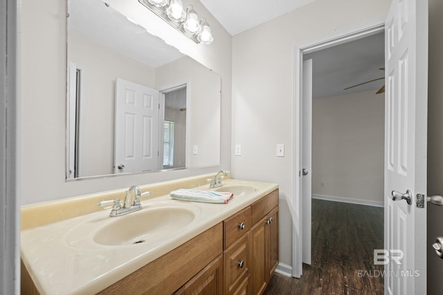 5584 Pensacola Ave, Orange Beach, AL 36561 - bathroom featuring double vanity, baseboards, a sink, and wood finished floors