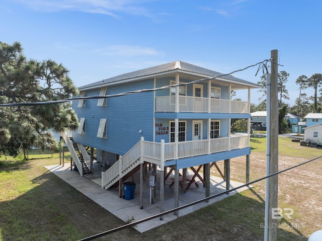5584 Pensacola Ave, Orange Beach, AL 36561 - rear view of property featuring covered porch, a yard, stairway, and a balcony