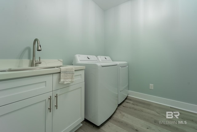 11341 Tall Timber Ln, Elberta, AL 36530 - washroom with separate washer and dryer, cabinet space, and light wood-style floors
