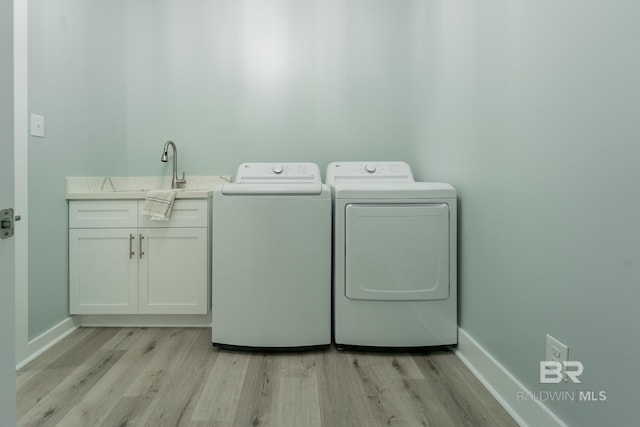 11341 Tall Timber Ln, Elberta, AL 36530 - washroom with washer and clothes dryer, light wood finished floors, and cabinet space