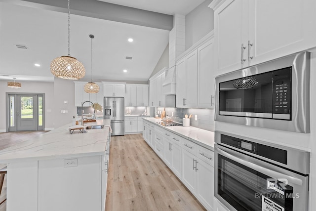 11341 Tall Timber Ln, Elberta, AL 36530 - kitchen featuring stainless steel appliances, tasteful backsplash, white cabinets, a kitchen island with sink, and lofted ceiling