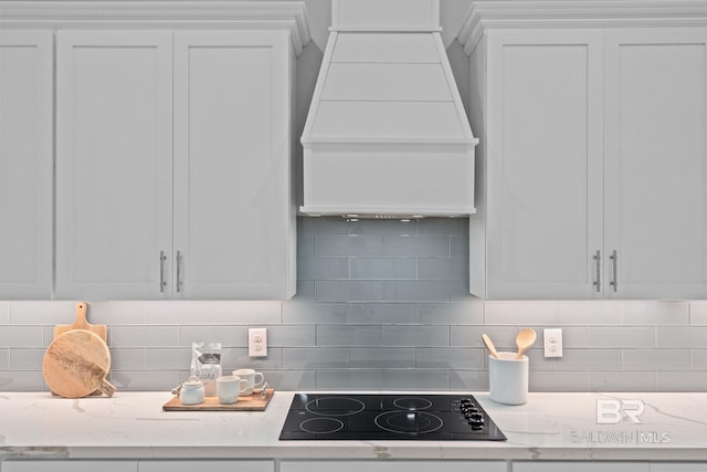 11341 Tall Timber Ln, Elberta, AL 36530 - kitchen with black electric cooktop, extractor fan, white cabinets, and tasteful backsplash