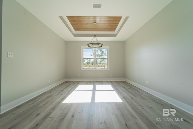 11341 Tall Timber Ln, Elberta, AL 36530 - spare room with a tray ceiling, light wood finished floors, and a chandelier